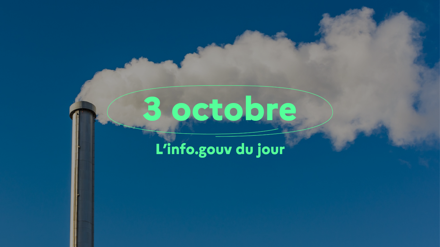 Une cheminée d'usine dégageant une fumée blanche se découpant sur un ciel bleu.