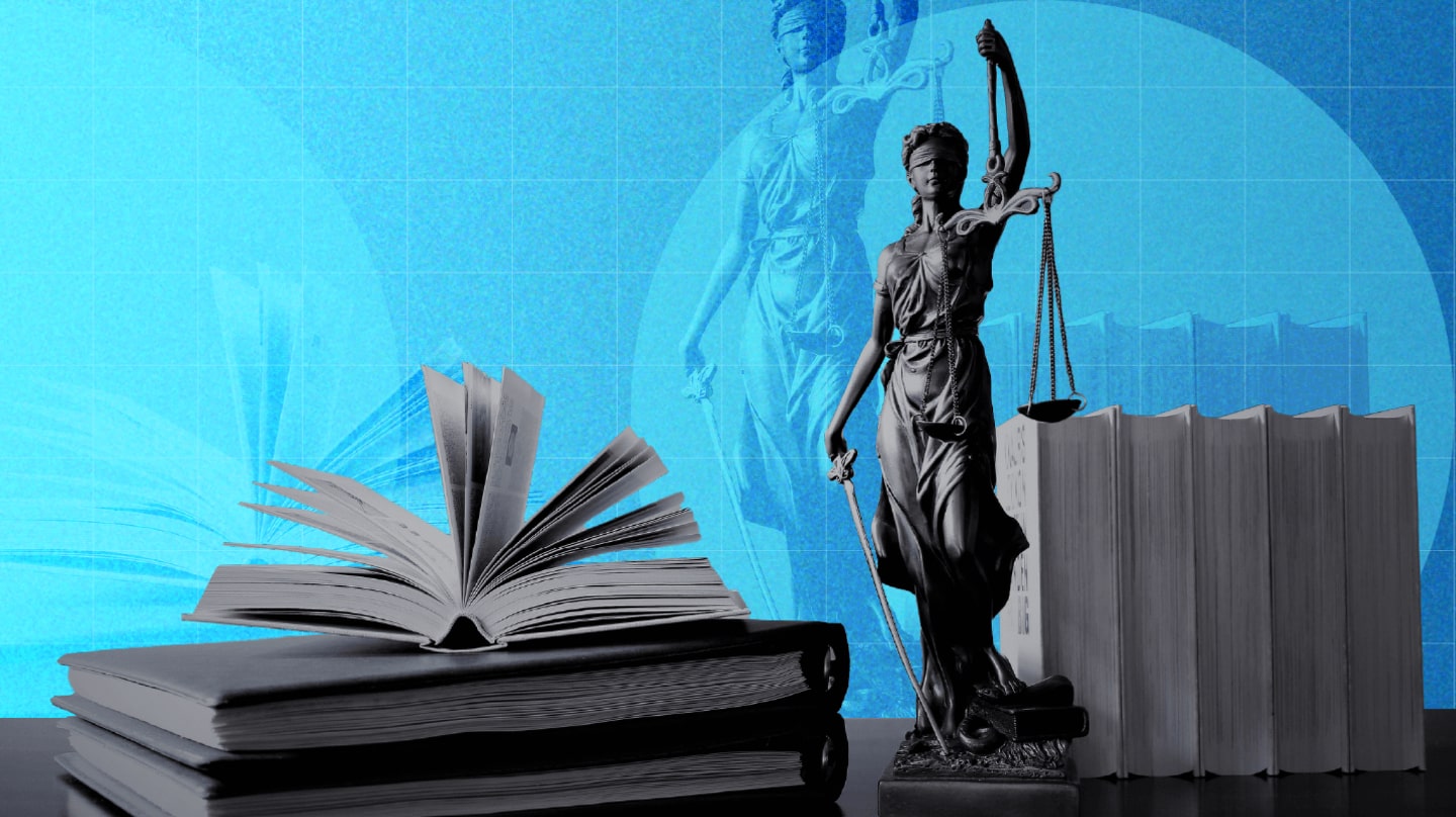 Une statue représentant la Justice avec une balance et une épée, et des livres.